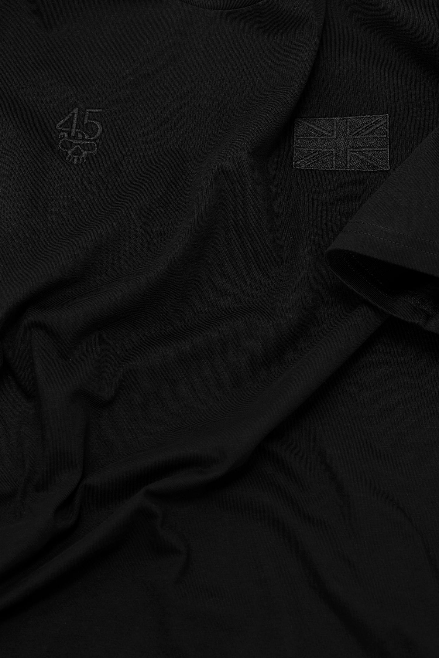 Close-up of tonal embroidery, cotton fabric and sleeve stitching on the Signature Tee