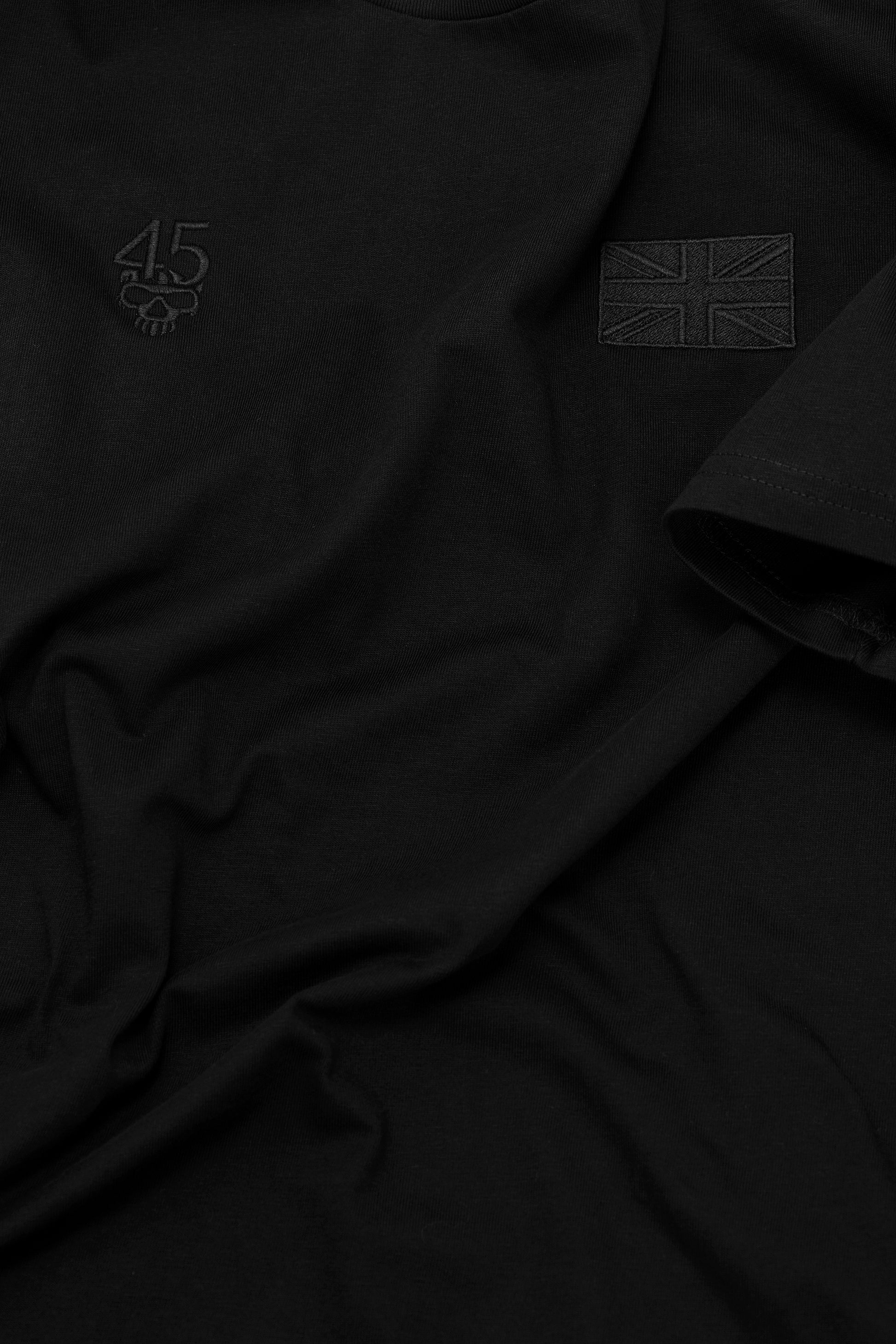 Close-up of tonal embroidery, cotton fabric and sleeve stitching on the Signature Tee